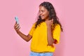 Young happy Indian woman making video call on mobile phone stands in studio Royalty Free Stock Photo