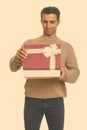 Young happy Iranian man opening gift box ready for Valentine`s day Royalty Free Stock Photo