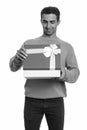 Young happy Iranian man opening gift box ready for Valentine`s day Royalty Free Stock Photo