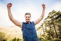 Young happy jogger standing on rock and cheering Royalty Free Stock Photo