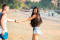 Young happy and joyful Caucasian adult romantic couple running and walking together while holding hands in summer wear on tropical Royalty Free Stock Photo