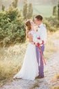 Young happy just married couple posing on the top of the mountain