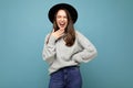 Young happy laughing joyful funny beautiful brunet woman. Trendy lady in casual grey sweater and stylish black hat Royalty Free Stock Photo