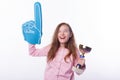 Young happy little girl is wearing fan glove and holding a winner trophy.