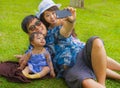 Young happy loving Asian Chinese family with parents and sweet baby daughter at city park together with father taking selfie pic Royalty Free Stock Photo