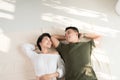 Young happy loving Asian couple boyfriend and girlfriend lying on the floor Royalty Free Stock Photo