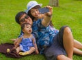 Young happy loving Asian Japanese family with parents and sweet baby daughter at city park together with father taking selfie pic Royalty Free Stock Photo