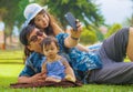 Young happy loving Asian Japanese family with parents and sweet baby daughter at city park together with father taking selfie pic Royalty Free Stock Photo