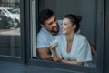 Young happy loving couple conversing and having coffee in window