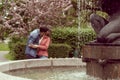 Young, happy, loving couple having date in the park near fountain. Relations, friendship and love. Royalty Free Stock Photo