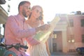 Young happy loving couple looking at map and sitting on scooter Royalty Free Stock Photo