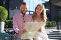 Young happy loving couple looking at map and sitting on scooter Royalty Free Stock Photo