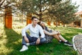 Young, happy, loving couple, sitting together on the grass in the Park, and enjoying each other, advertising, and inserting text Royalty Free Stock Photo