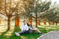 Young, happy, loving couple, sitting together on the grass in the Park, and enjoying each other, advertising, and inserting text Royalty Free Stock Photo