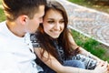 Young, happy, loving couple, sitting together on the grass in the Park, and enjoying each other, advertising, and inserting text Royalty Free Stock Photo