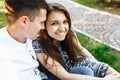 Young, happy, loving couple, sitting together on the grass in the Park, and enjoying each other, advertising, and inserting text Royalty Free Stock Photo