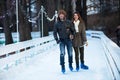 Young happy loving couple skating at ice rink outdoors Royalty Free Stock Photo