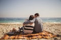 Young happy loving family with small child, enjoying time at beach sitting and hugging near ocean, happy lifestyle family concept Royalty Free Stock Photo