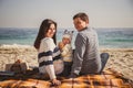 Young happy loving family with small child, enjoying time at beach sitting and hugging near ocean, happy lifestyle family concept Royalty Free Stock Photo