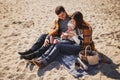 Young happy loving family with small child at picnic, enjoying time at beach sitting and hugging near ocean, happy lifestyle famil Royalty Free Stock Photo