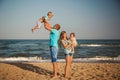 Young happy loving family with small kids having fun at beach together near the ocean, happy lifestyle family concept