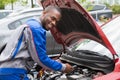 Mechanic Testing Car Battery With Multimeter