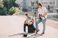 Young and happy male street musicians playing guitar and djembe
