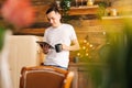 Young happy man in casual clothes holding digital tablet and drinking coffee Royalty Free Stock Photo