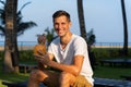 Young happy man drinks a fresh coconut