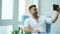 Young happy man have online video chat using digital tablet computer sitting on balcony in modern loft apartment Royalty Free Stock Photo