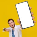 Young happy man holding smartphone showing a white empty screen check this out, cellphone display mock up mobile app Royalty Free Stock Photo