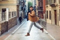 Young happy man jumping wearing winter clothes in urban background Royalty Free Stock Photo