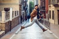 Young happy man jumping wearing winter clothes in urban background Royalty Free Stock Photo