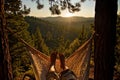 A young happy man relaxes in a hammock atop a mountain while lying in the hammock. Royalty Free Stock Photo