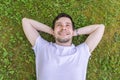 Young happy man is relaxing and lying on green grass Royalty Free Stock Photo