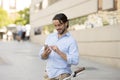 Young happy man smiling using mobile phone on vintage cool retro bike Royalty Free Stock Photo