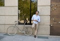 Young happy man smiling using mobile phone on vintage cool retro bike Royalty Free Stock Photo