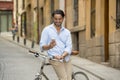 Young happy man smiling using mobile phone on vintage cool retro bike Royalty Free Stock Photo