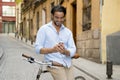 Young happy man smiling using mobile phone on vintage cool retro bike Royalty Free Stock Photo