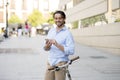 Young happy man smiling using mobile phone on vintage cool retro bike Royalty Free Stock Photo