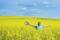 Young happy man standing on a meadow with raising hands and looking to a sky. Royalty Free Stock Photo