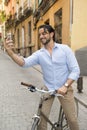 Young happy man taking selfie with mobile phone on retro cool vintage bike Royalty Free Stock Photo