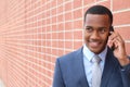 Young happy man talking on mobile phone isolated outdoors city wall urban background Royalty Free Stock Photo