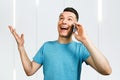 Young happy man talking telephone in blue t-shirt Royalty Free Stock Photo