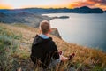 Young happy man on the top of rock in mountains at sunset in summer. Concept of active lifestyle and traveling. Royalty Free Stock Photo