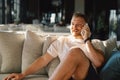 Young happy man using mobile phone in hotel lobby. Royalty Free Stock Photo