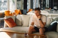 Young happy man using mobile phone in hotel lobby. Royalty Free Stock Photo