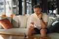 Young happy man using mobile phone in hotel lobby. Royalty Free Stock Photo