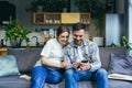 Young happy married couple husband and pregnant woman at home sitting on sofa using phone smiling Royalty Free Stock Photo
