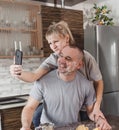 a young happy married couple smeared with flour takes a selfie in the kitchen Royalty Free Stock Photo